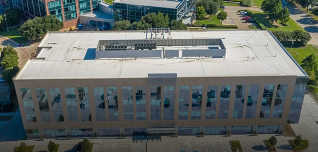 Aerial view of modern office building with flat roof installed by commercial roofing contractor.